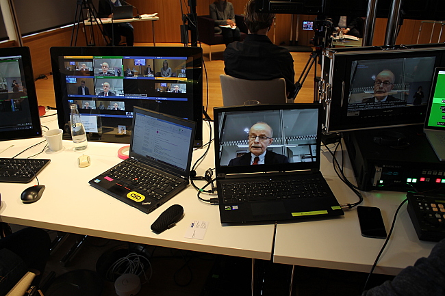 Das Bild zeigt mehrere Notebooks mit der Live-Übertragung der Veranstaltung, auf dem Bildschirm ist Bernhard Franke zu sehen