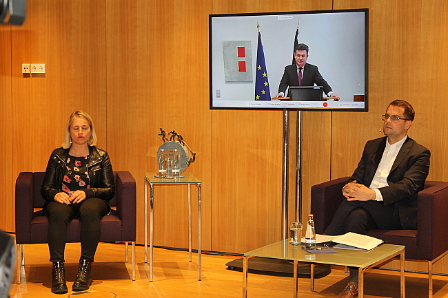 Hubertus Heil ist auf einem Bildschirm zu sehen. Links sitzt Verena Bentele, rechts Moderator Samuel Beuttler-Bohn.